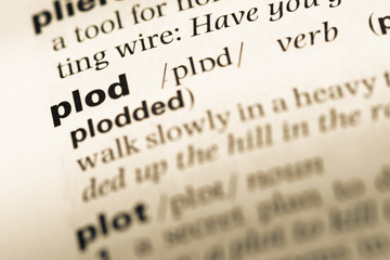 Close up of old English dictionary page with word plod