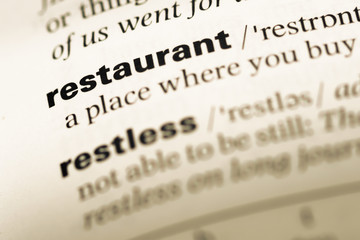 Close up of old English dictionary page with word restaurant