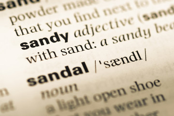 Close up of old English dictionary page with word sandy
