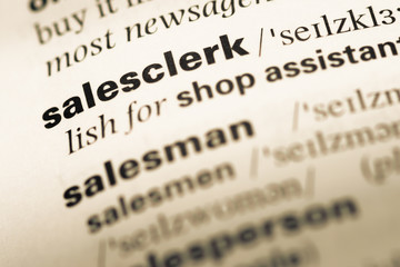 Close up of old English dictionary page with word salesclerk
