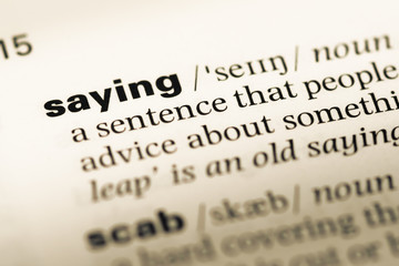 Obraz premium Close up of old English dictionary page with word saying