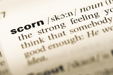 Close up of old English dictionary page with word scorn