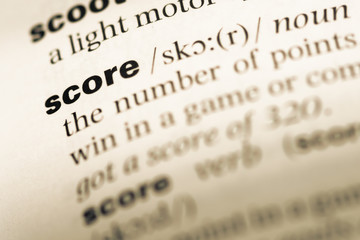 Close up of old English dictionary page with word score