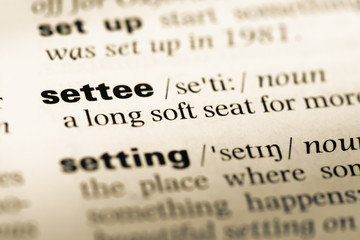 Fototapeta premium Close up of old English dictionary page with word settee