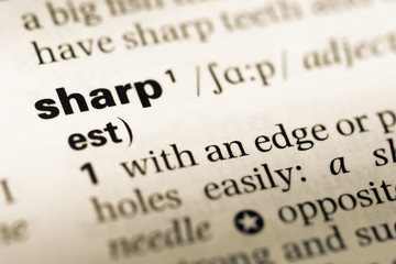 Obraz premium Close up of old English dictionary page with word sharp