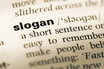 Obraz premium Close up of old English dictionary page with word slogan