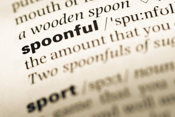 Close up of old English dictionary page with word spoonful