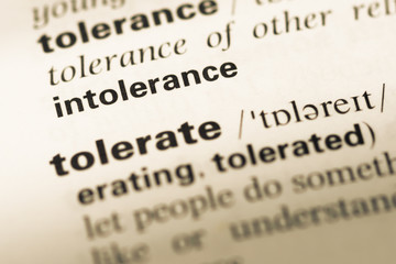 Obraz premium Close up of old English dictionary page with word intolerance