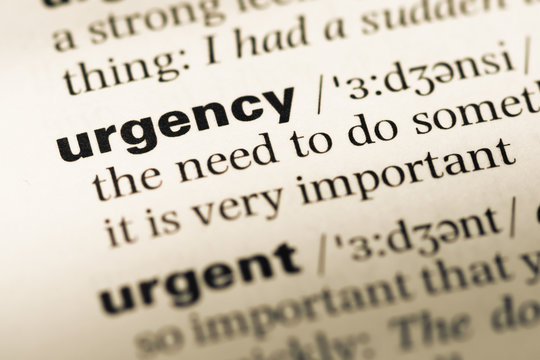 Close up of old English dictionary page with word urgency