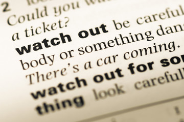 Obraz premium Close up of old English dictionary page with word watch out