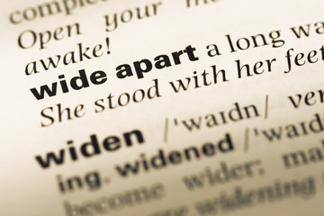 Fototapeta premium Close up of old English dictionary page with word wide apart