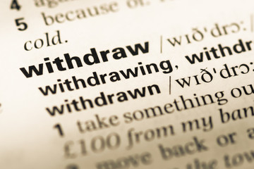 Close up of old English dictionary page with word withdraw