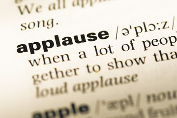 Obraz premium Close up of old English dictionary page with word applause