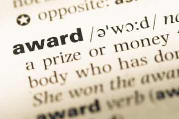 Obraz premium Close up of old English dictionary page with word award