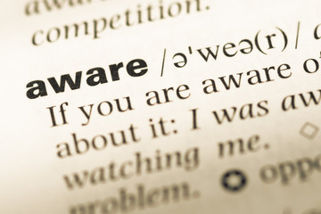 Fototapeta premium Close up of old English dictionary page with word aware