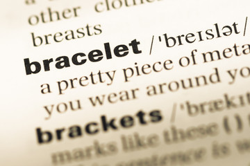 Obraz premium Close up of old English dictionary page with word bracelet