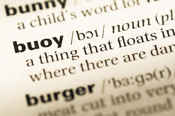 Obraz premium Close up of old English dictionary page with word buoy