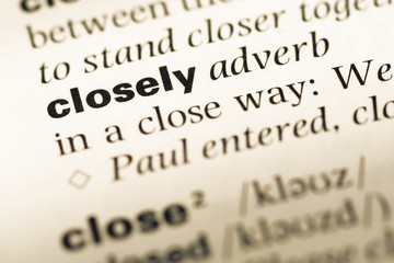 Close up of old English dictionary page with word closely