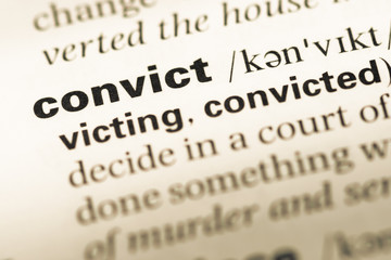 Obraz premium Close up of old English dictionary page with word convict