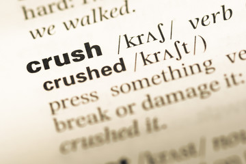 Close up of old English dictionary page with word crush