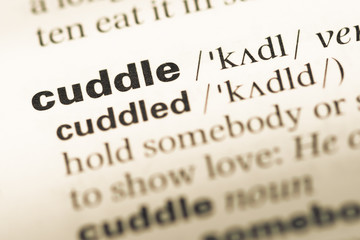 Obraz premium Close up of old English dictionary page with word cuddle