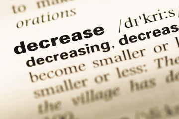 Obraz premium Close up of old English dictionary page with word decrease