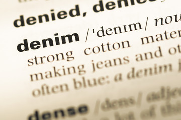 Close up of old English dictionary page with word denim