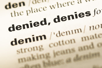 Close up of old English dictionary page with word denied denies