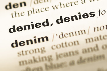 Fototapeta premium Close up of old English dictionary page with word denied denies