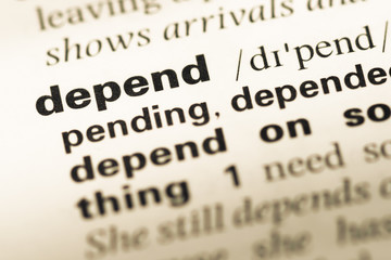 Close up of old English dictionary page with word depend