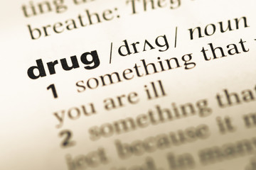 Close up of old English dictionary page with word drug