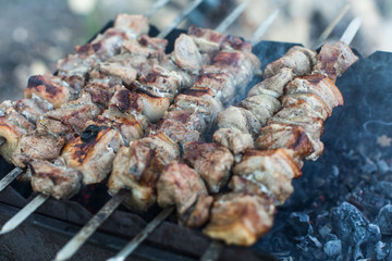 meat on grill with flames in village