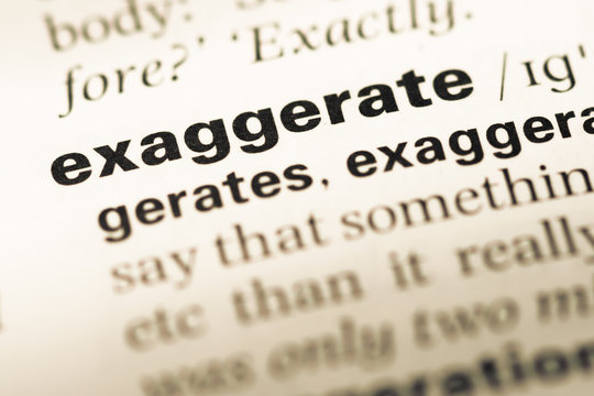 Close up of old English dictionary page with word exaggerate