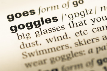 Fototapeta premium Close up of old English dictionary page with word goggles