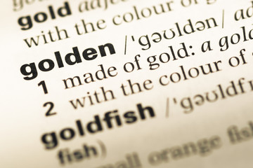Obraz premium Close up of old English dictionary page with word golden