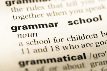 Obraz premium Close up of old English dictionary page with word grammar school