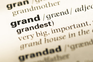 Obraz premium Close up of old English dictionary page with word grand