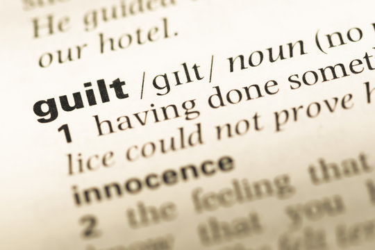 Close up of old English dictionary page with word guilt