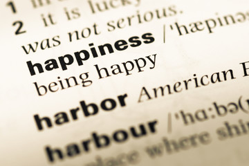 Close up of old English dictionary page with word happiness