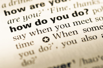 Fototapeta premium Close up of old English dictionary page with word how do you do