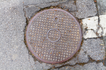 Rusty, grunge manhole cover in original background