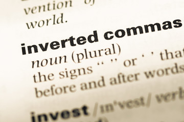 Obraz premium Close up of old English dictionary page with word inverted comma