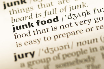 Fototapeta premium Close up of old English dictionary page with word junk food