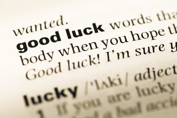 Close up of old English dictionary page with word good luck