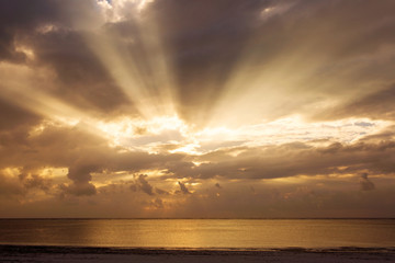 Beautiful sunrise over a ocean and beach with colorful clouds an