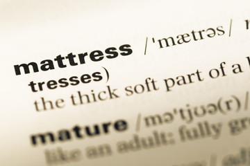 Obraz premium Close up of old English dictionary page with word mattress