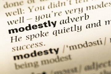 Fototapeta premium Close up of old English dictionary page with word modestly