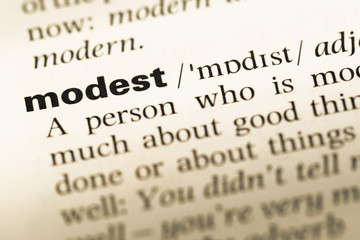 Fototapeta premium Close up of old English dictionary page with word modest