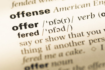 Close up of old English dictionary page with word offer