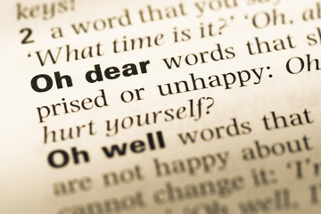 Fototapeta premium Close up of old English dictionary page with word oh dear